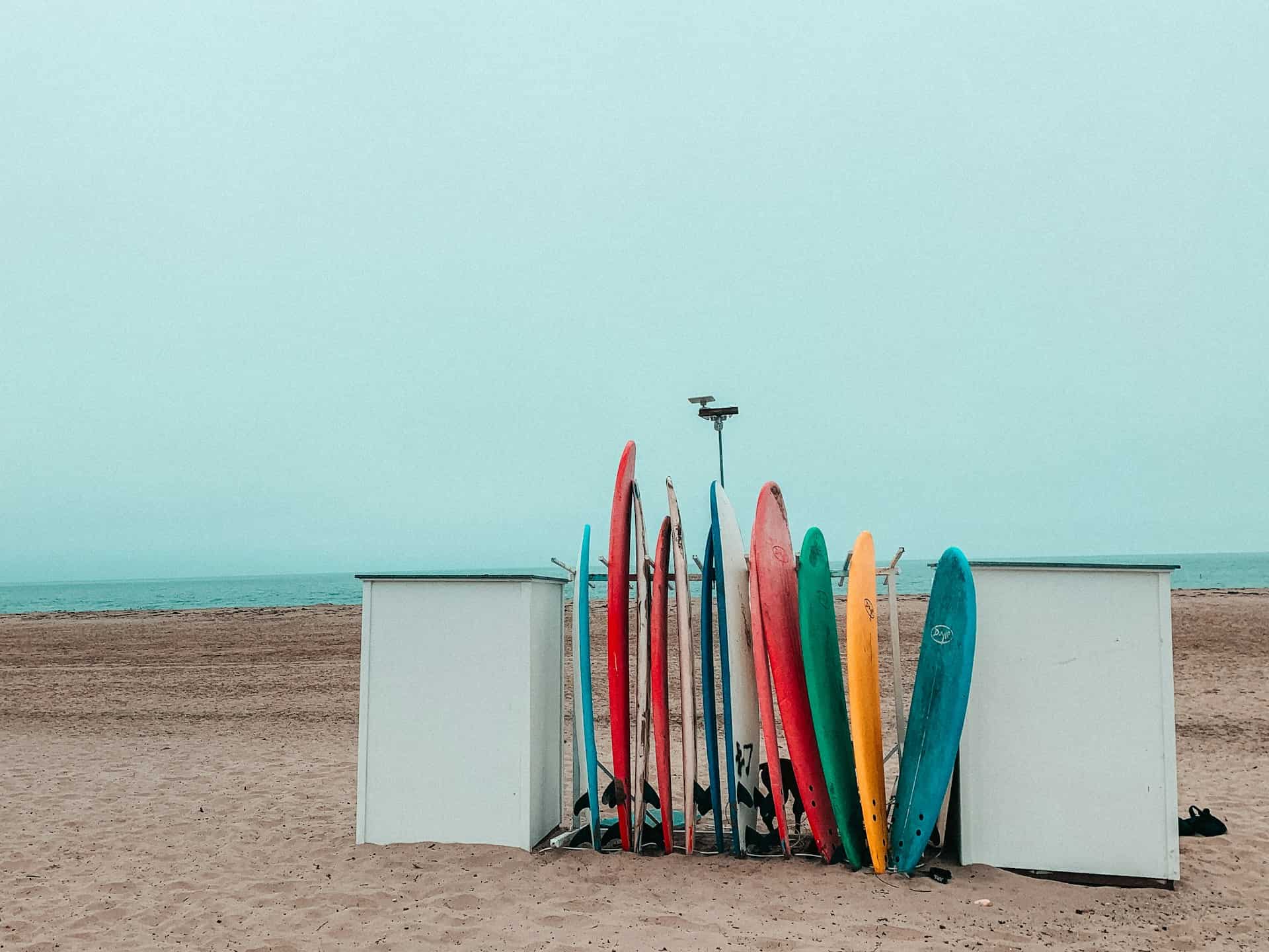 best surf camps - How to Find the Best Surf Camps Around the World Surf boards on the beach